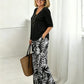 Set bestaande uit een damesblouse met V-hals en een broek met wijde pijpen en print