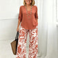 Set bestaande uit een damesblouse met V-hals en een broek met wijde pijpen en print
