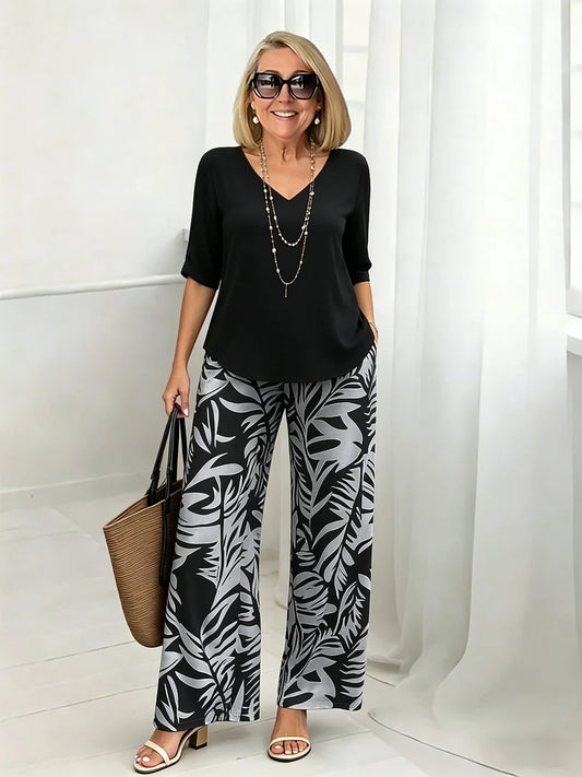 Set bestaande uit een damesblouse met V-hals en een broek met wijde pijpen en print