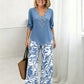 Set bestaande uit een damesblouse met V-hals en een broek met wijde pijpen en print